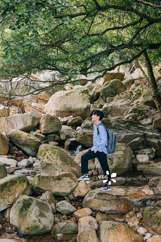 男子背包客在森林里拿着手机图片素材