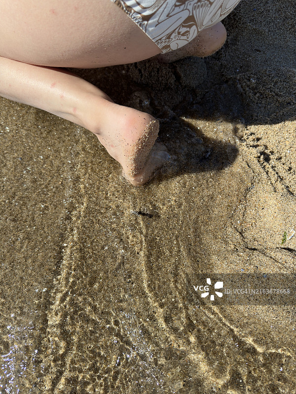 年轻女人在沙滩上的脚，或与家人度假的一天，家庭度假图片素材