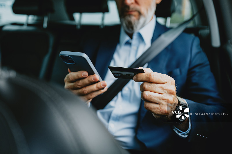 商人使用智能手机和信用卡进行在线支付图片素材