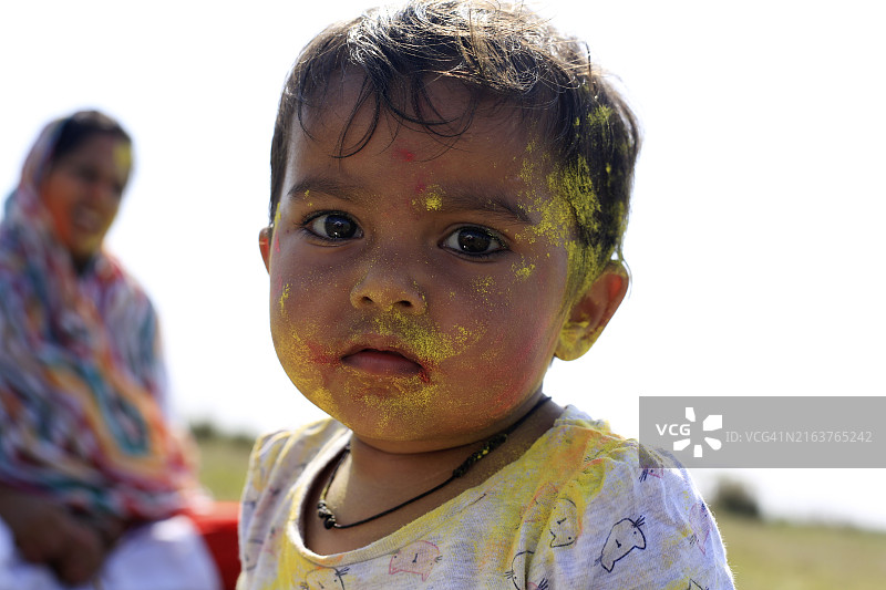 可爱的小宝宝在户外大自然中玩洒红节的颜色图片素材