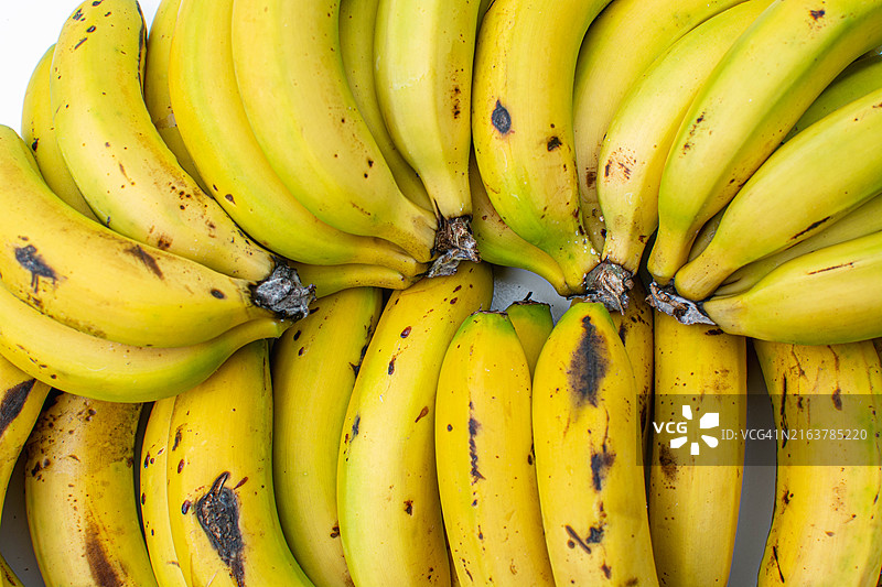 农贸市场上的多串新鲜成熟香蕉图片素材