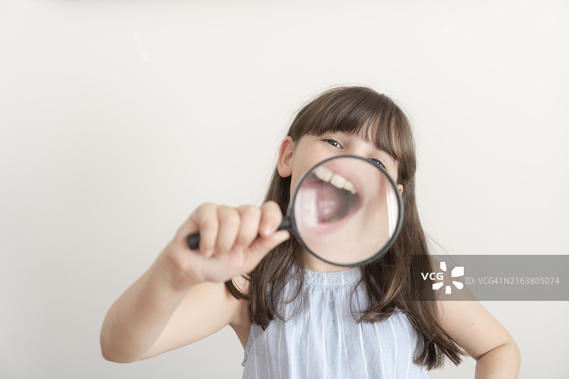 持放大镜的女孩图片素材
