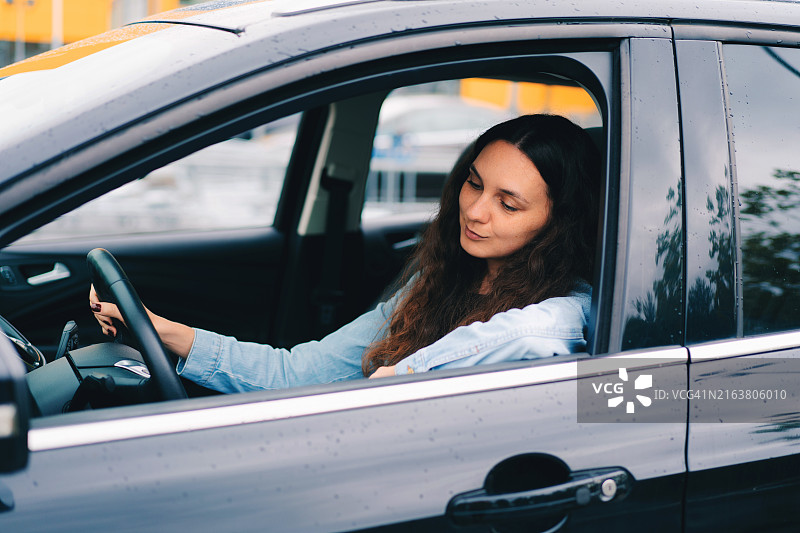 年轻女子坐在车里，汽车租赁。交通运输概念图片素材