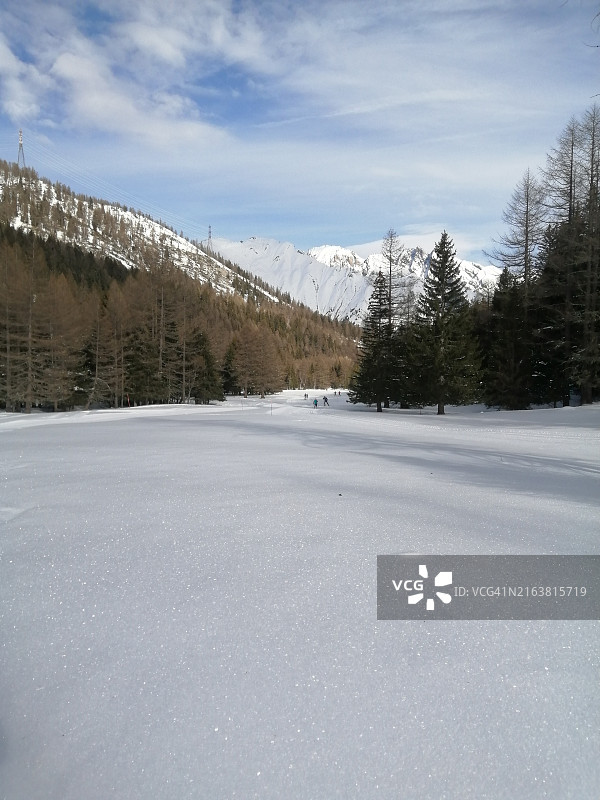 远处有滑雪者的雪山景色图片素材