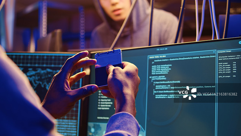 黑客持有包含计算机漏洞的固态硬盘图片素材