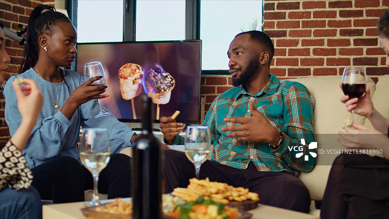 客人在家庭聚会上欢笑交谈，并向主人赠送礼物图片素材