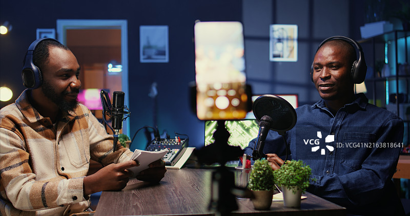 男人们在演播室用手机拍摄节目并谈论政治图片素材