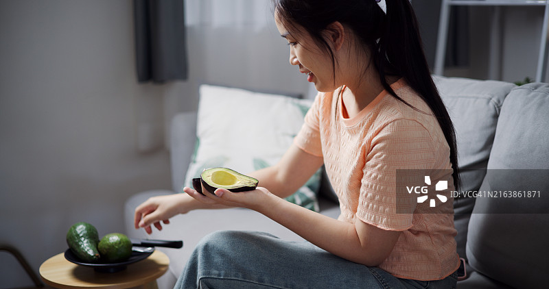 女人拿着半个鳄梨图片素材