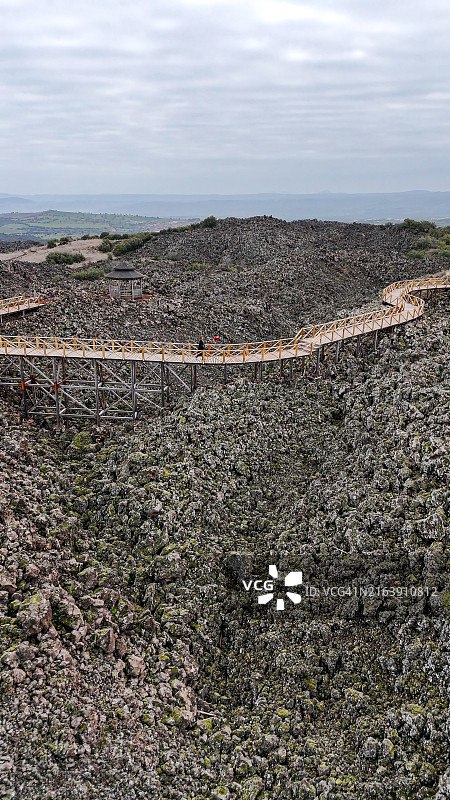 马尼萨库拉萨利赫利联合国教科文组织世界地质公园和火山公园以及Divlit Tepe火山群空中鸟瞰，位于库拉火山地质公园，一位悲伤的年轻女子手拿红色气球走过图片素材