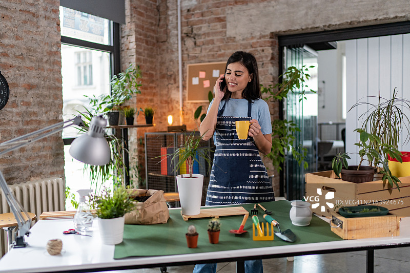 花艺师在智能手机上与客户交谈并接单图片素材