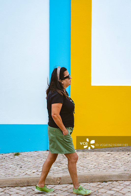 女人在埃里塞拉的彩色墙壁前行走图片素材