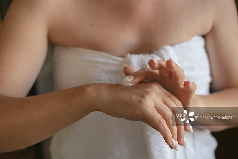 女人在手上涂抹润肤霜或抗衰老霜图片素材