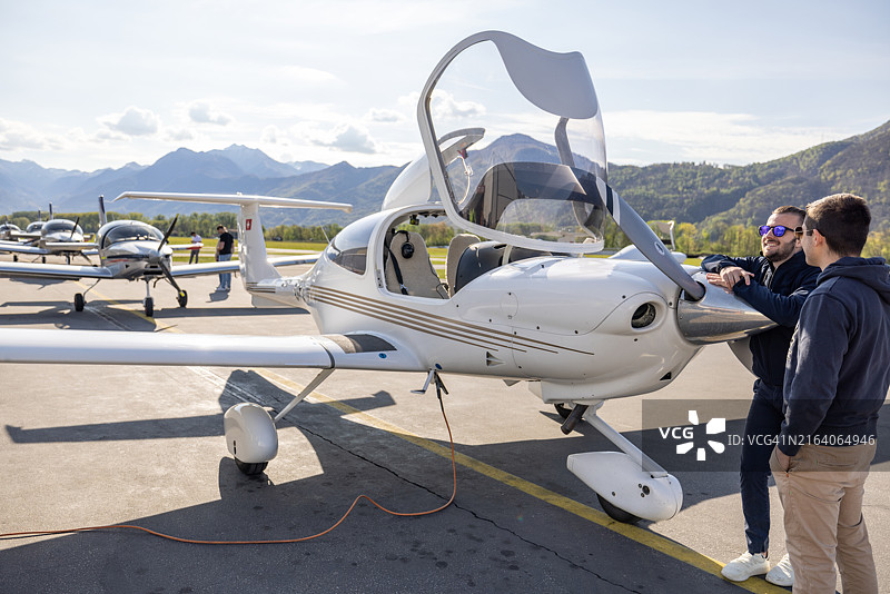 地勤人员和飞行员准备轻型飞机飞行图片素材