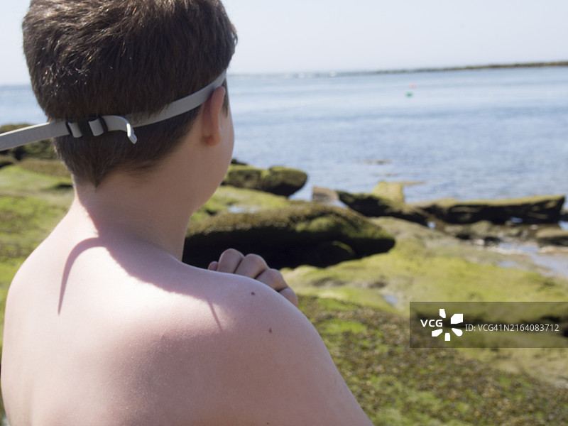 小男孩看着海滩的 horizon图片素材