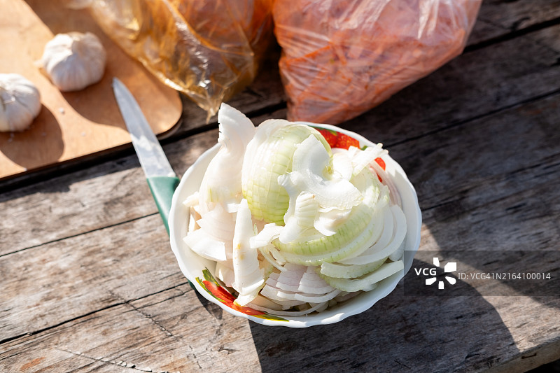 碗中洋葱圈，木桌上。手抓饭的洋葱、大蒜和胡萝卜配料图片素材
