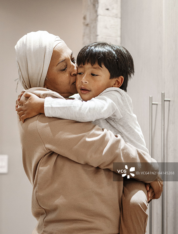 奶奶亲吻男孩的脸颊图片素材