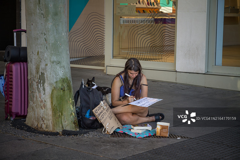 年轻女人和她的狗在街上寻求帮助图片素材