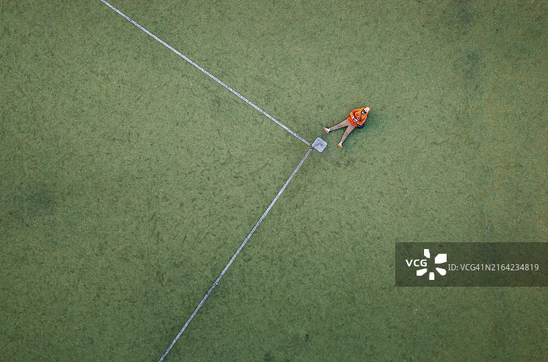 男人躺在棒球场上用无人机自拍图片素材