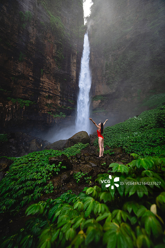 在印度尼西亚东爪哇卡帕斯比鲁瀑布穿比基尼的女人肖像图片素材