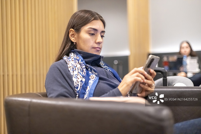 在候车室查看手机的女人图片素材