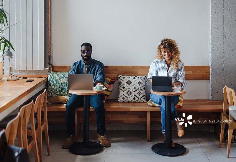 在舒适的咖啡馆里用笔记本电脑工作的人们图片素材