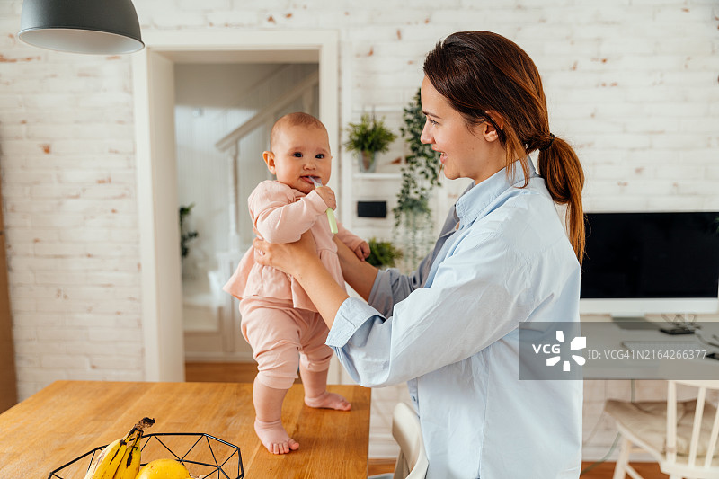 母亲抱着宝宝欢呼雀跃图片素材
