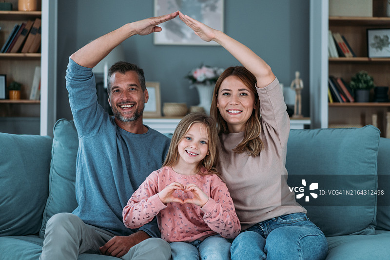 幸福家庭在客厅用手臂搭屋顶图片素材
