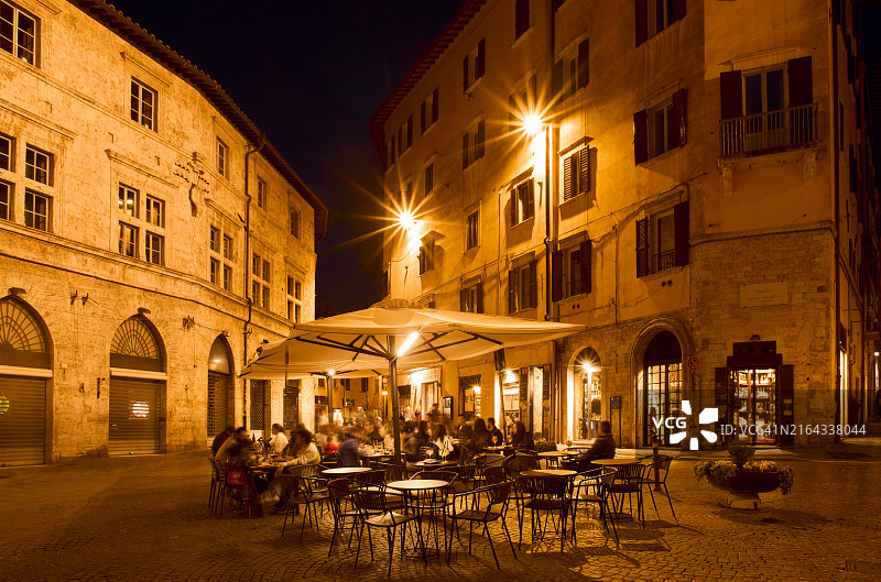 人们晚上坐在翁布里亚佩鲁贾的酒吧外面图片素材