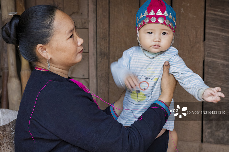 老挝北部村庄里抱着婴儿的老挝妈妈图片素材