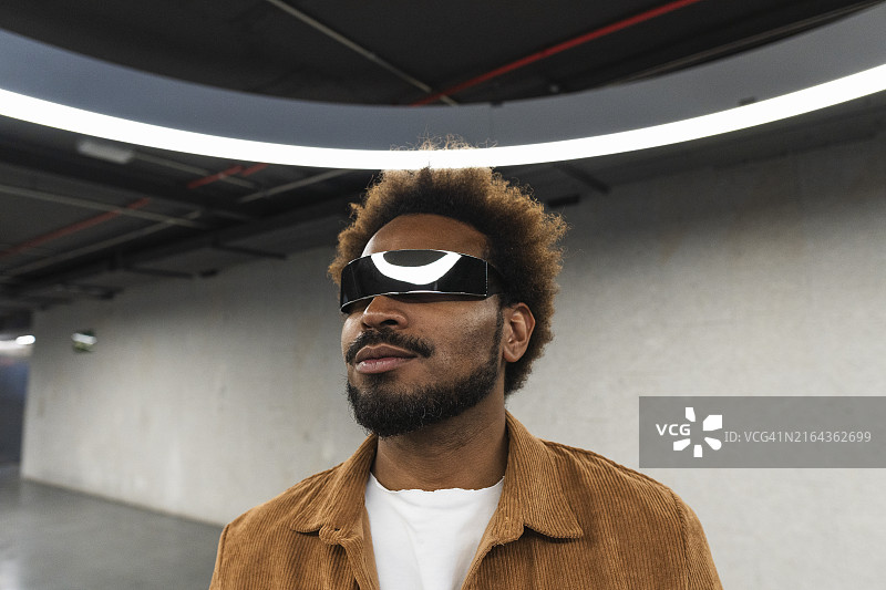 智能眼镜男性在灯火通明停车场图片素材