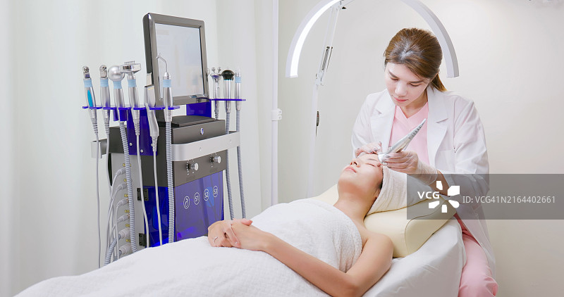 亚洲美容师使用美容设备图片素材