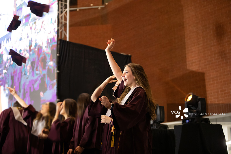 毕业典礼上抛帽子的快乐毕业生图片素材