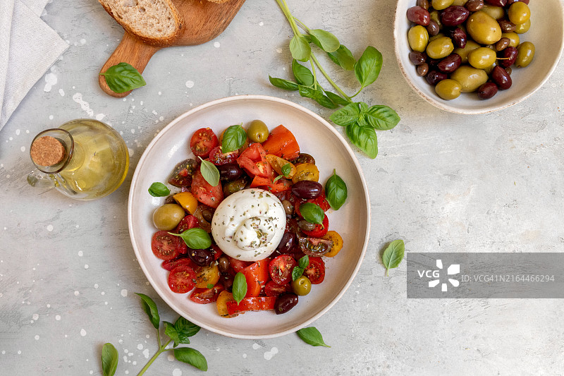 意大利布拉塔奶酪配番茄、橄榄、罗勒和橄榄油沙拉图片素材