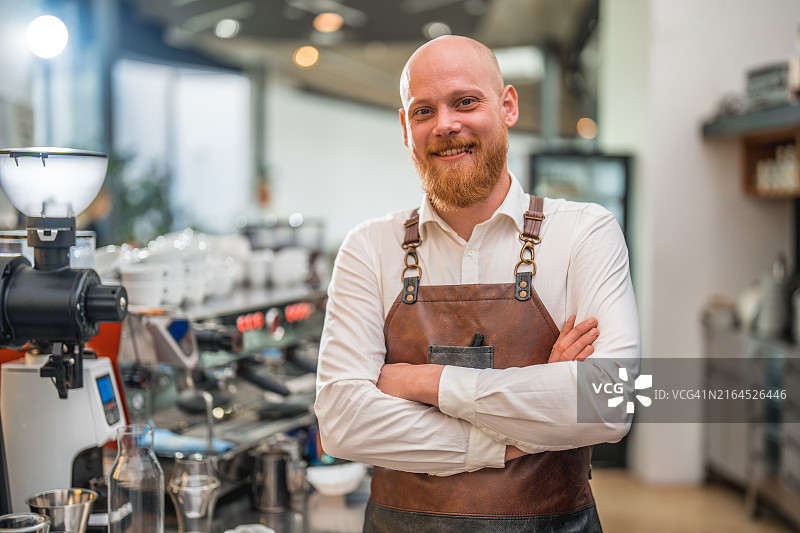 吧台前双手交叉的熟练白人男咖啡师图片素材