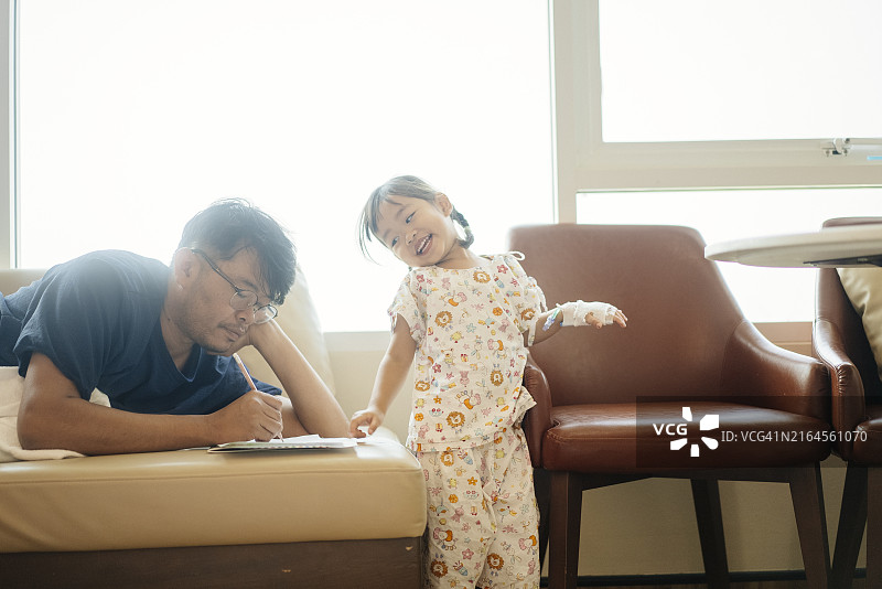 亚洲父亲在医院里关心和照顾可爱的亚洲女儿，接受静脉滴注护理：儿科恢复场景，手部静脉滴注图片素材
