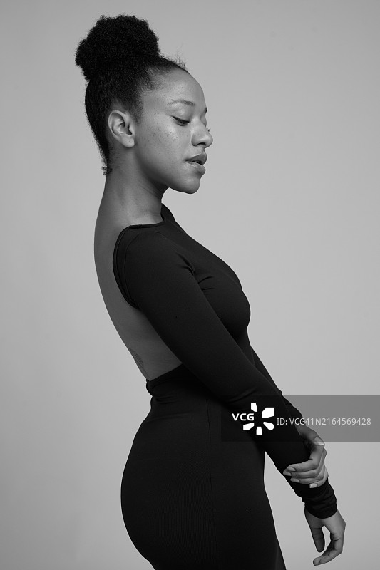 在工作室摆姿势的年轻黑人女演员，背对着镜头图片素材
