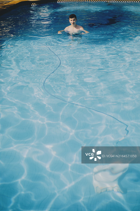 游泳池中年轻男青年的广角视图图片素材