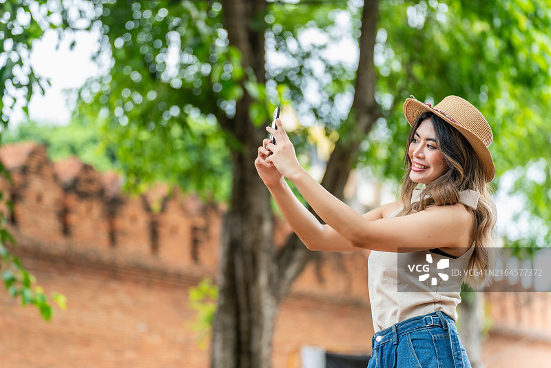 亚洲女游客在清迈塔佩门捕捉精彩瞬间图片素材