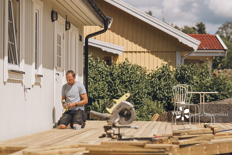 男人在花园里建造木制露台图片素材