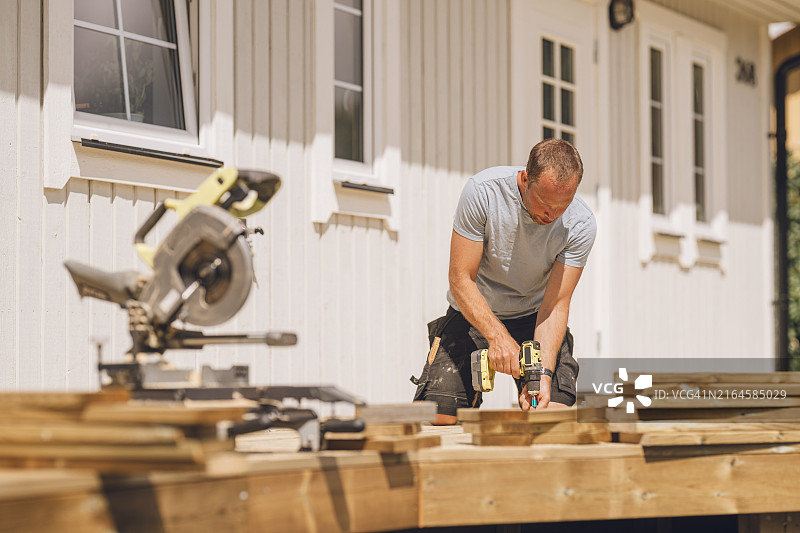 男人在花园里建造木制露台图片素材