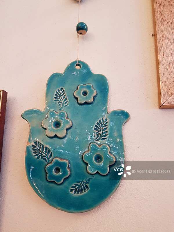 耶路撒冷马哈内·耶胡达市场的绿松石手部特写，象征幸运和祝福，可预防邪恶之眼（犹太北非传统）图片素材