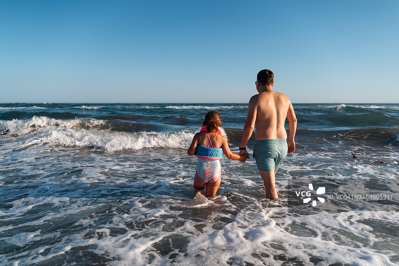 父女在海滩的波浪中玩耍图片素材