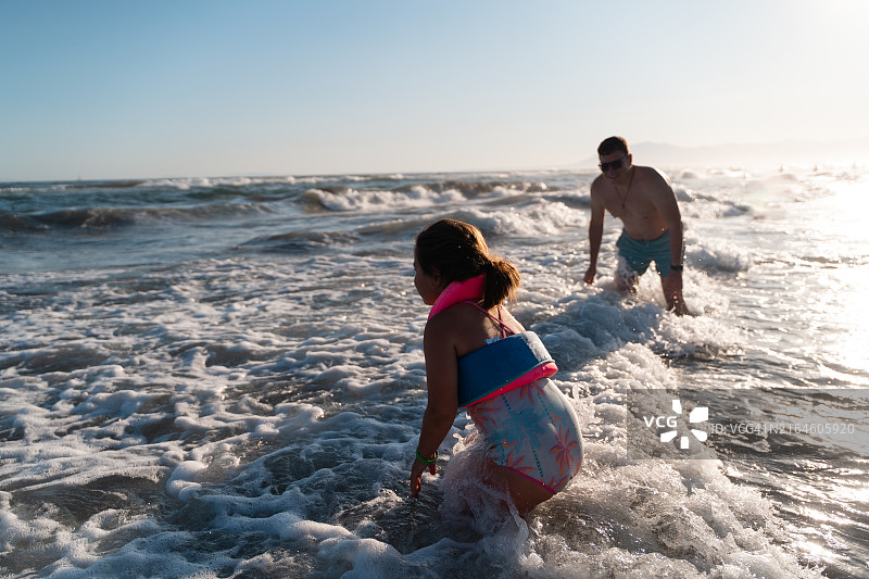 父女在海滩的波浪中玩耍图片素材