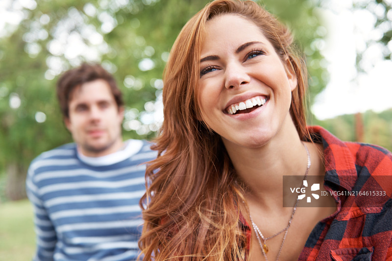 在自然公园里，女子和男子愉快地思考，享受户外约会，一起放松。女孩在树林里面带微笑，思考浪漫的灵感，感受伴侣的爱和关系图片素材