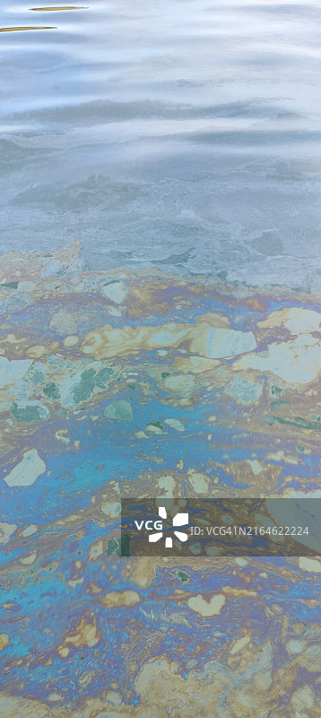 码头海面被渔船清洗后的油污覆盖图片素材