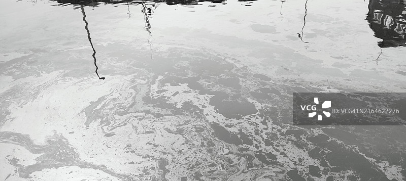 码头海面被渔船清洗后的油污覆盖图片素材