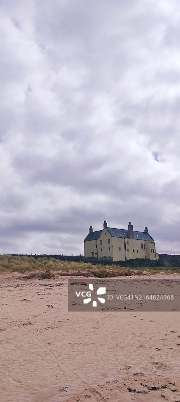 多云天空下靠近海滩的巴尔纳基尔湾和巴尔纳基尔房子图片素材