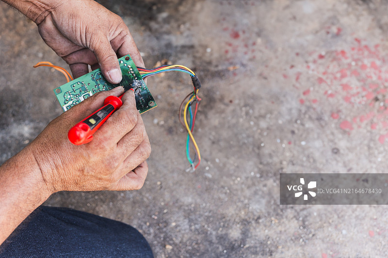 技术员检查遥控器主板背面，泰国图片素材