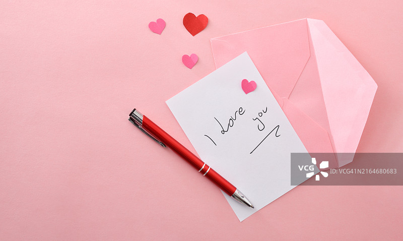 粉色背景上的浪漫便条、粉色信封和钢笔图片素材