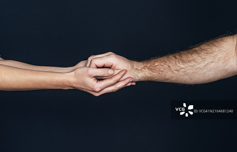 女人温柔地握着男人的手，给予支持图片素材